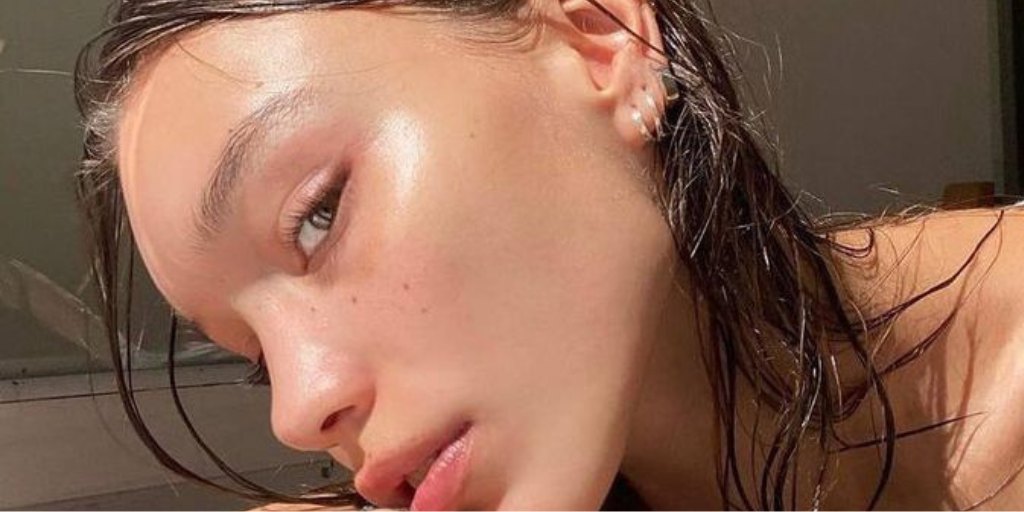 Close-up of a woman with wet hair and glowing, dewy skin.
