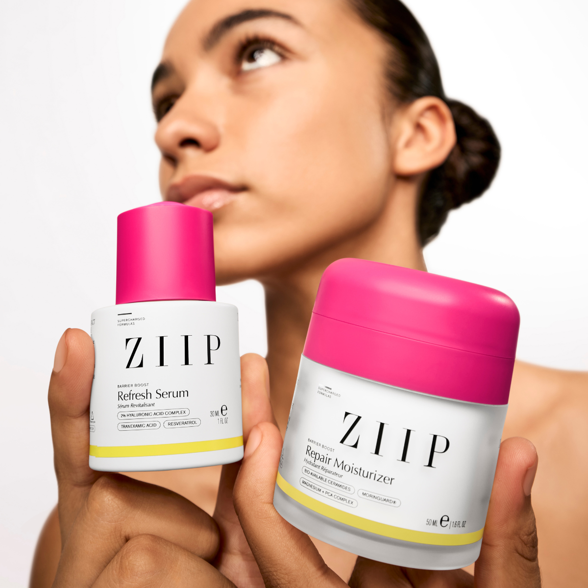 Woman holding ZIIP Barrier Boost bundle with Refresh serum and Repair moisturizer