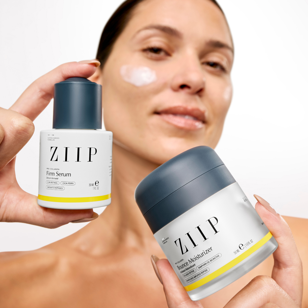 Woman holding ZIIP Pro Collagen serum and moisturizer bundle with product applied to cheek